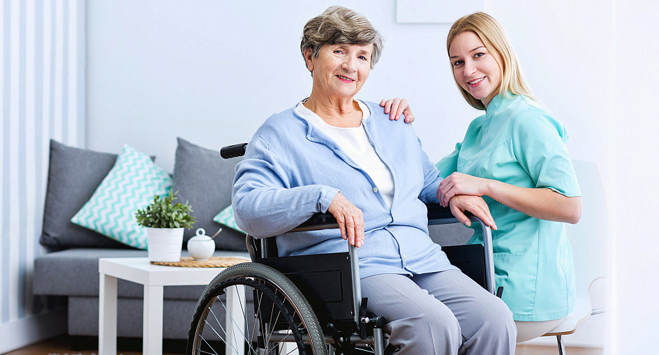 female caregiver in uniform and senior woman smiling