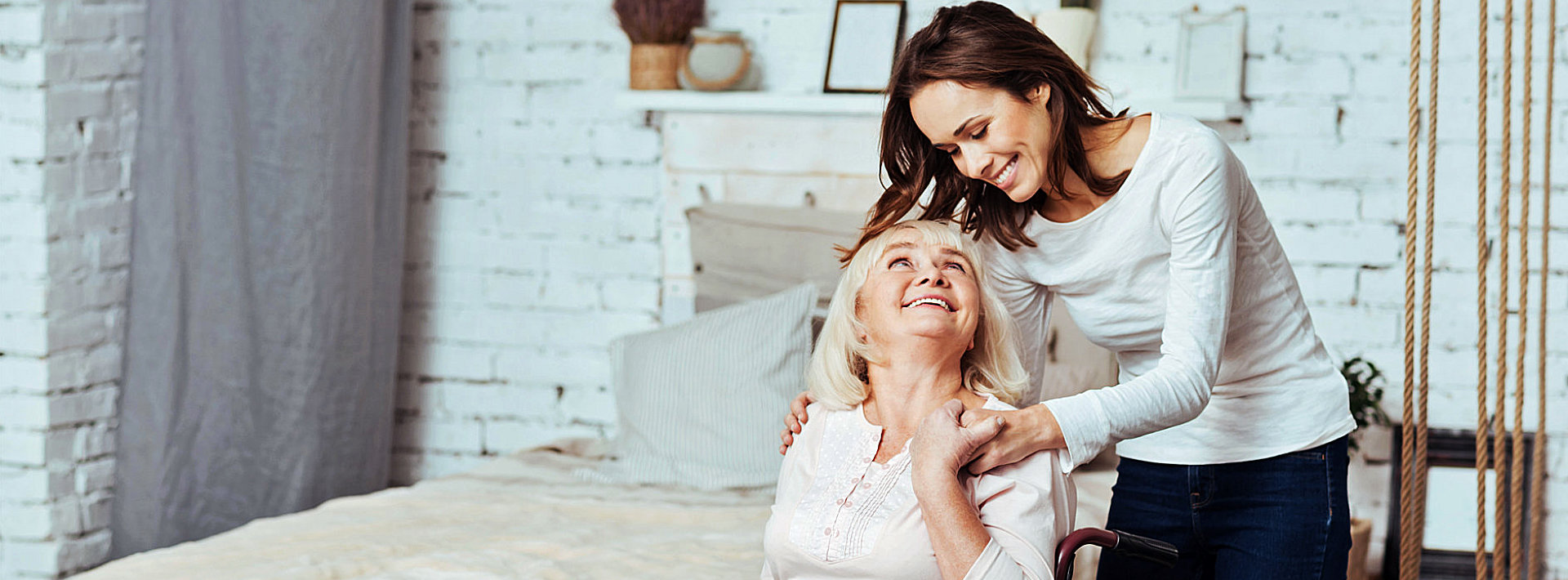 caregiver and senior woman smiling while looking at each other