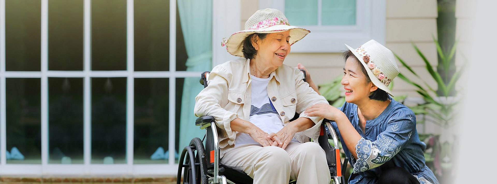 caregiver and senior man both wearing hat