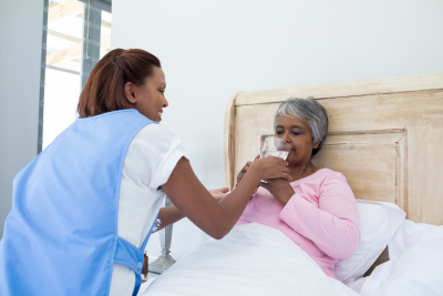 young woman assisting the old woman in bedroom