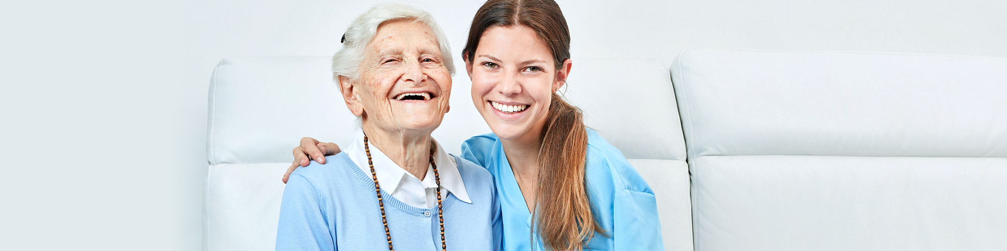 female caregiver and senior woman smiling