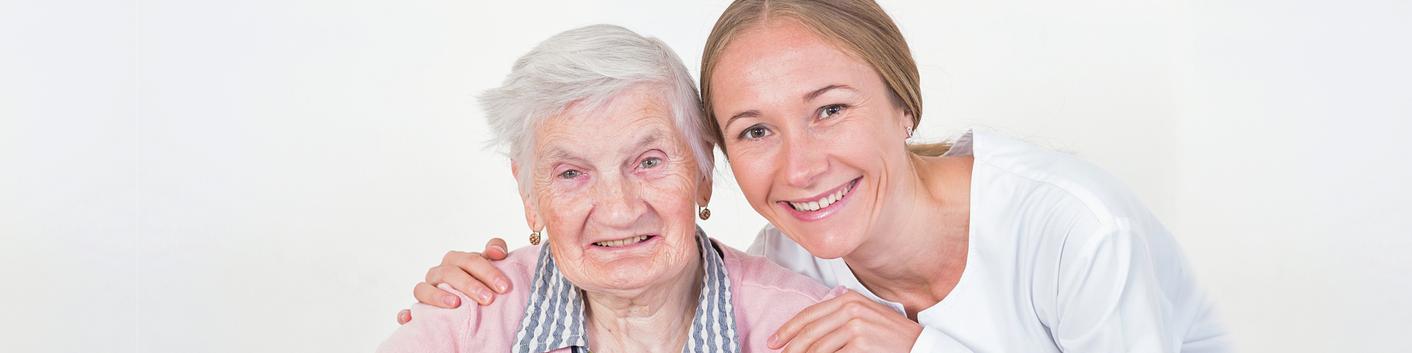 female caregiver and senior woman smiling